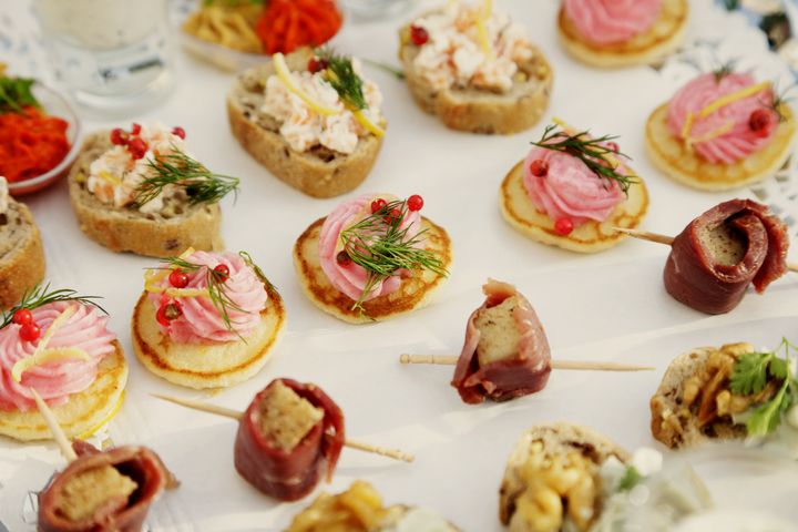 Canapés on blini and toast with smoked fish, cream and fresh dill.