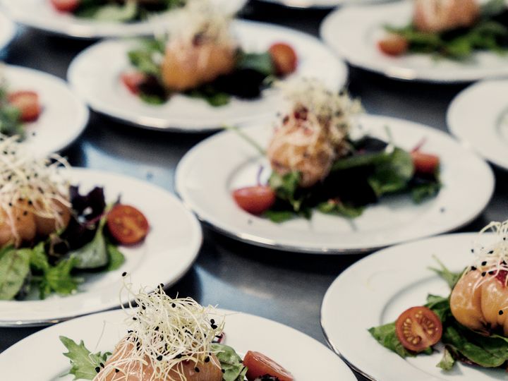 Rows of plated starters with greens and tomato, ready to be served.